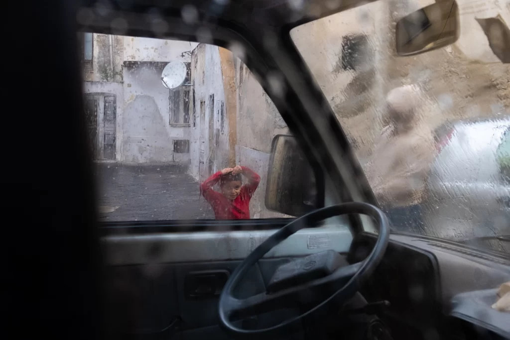 Bambino gioca sotto l'acqua durante la Vendemmia
